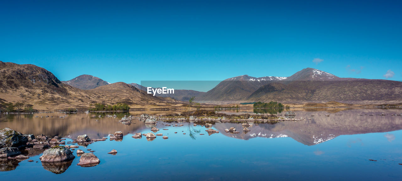 Panoramic view of the reflections of the black mount hills in lochan na h-achlaise on rannoch moor