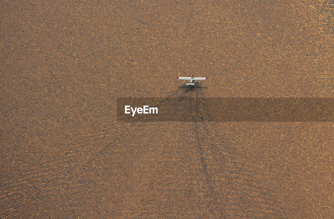 Aerial view of airplane in sea during sunset