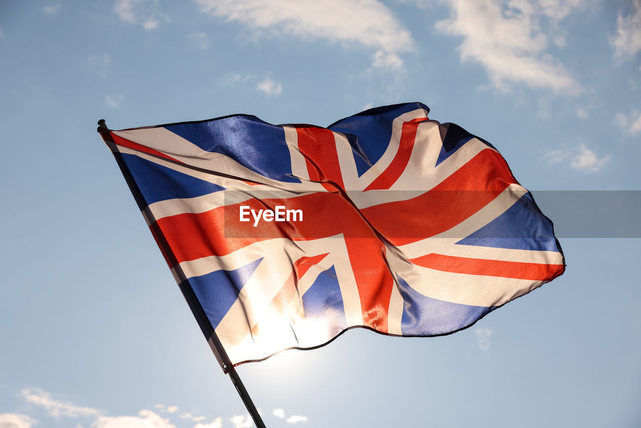 Uk great britain national flag flying and waving in the wind, backlit in golden hour