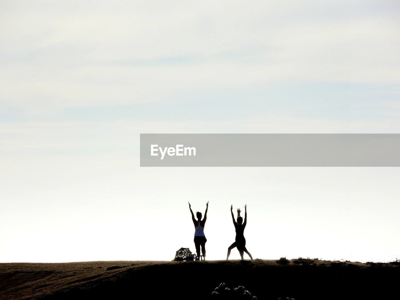 Silhouette women posing on landscape against sky