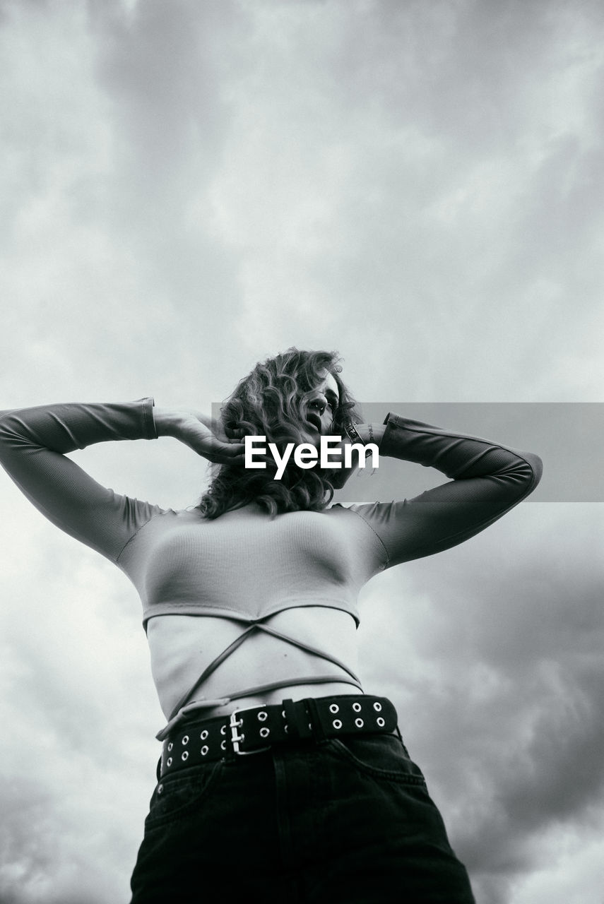 Low angle view of woman standing against sky