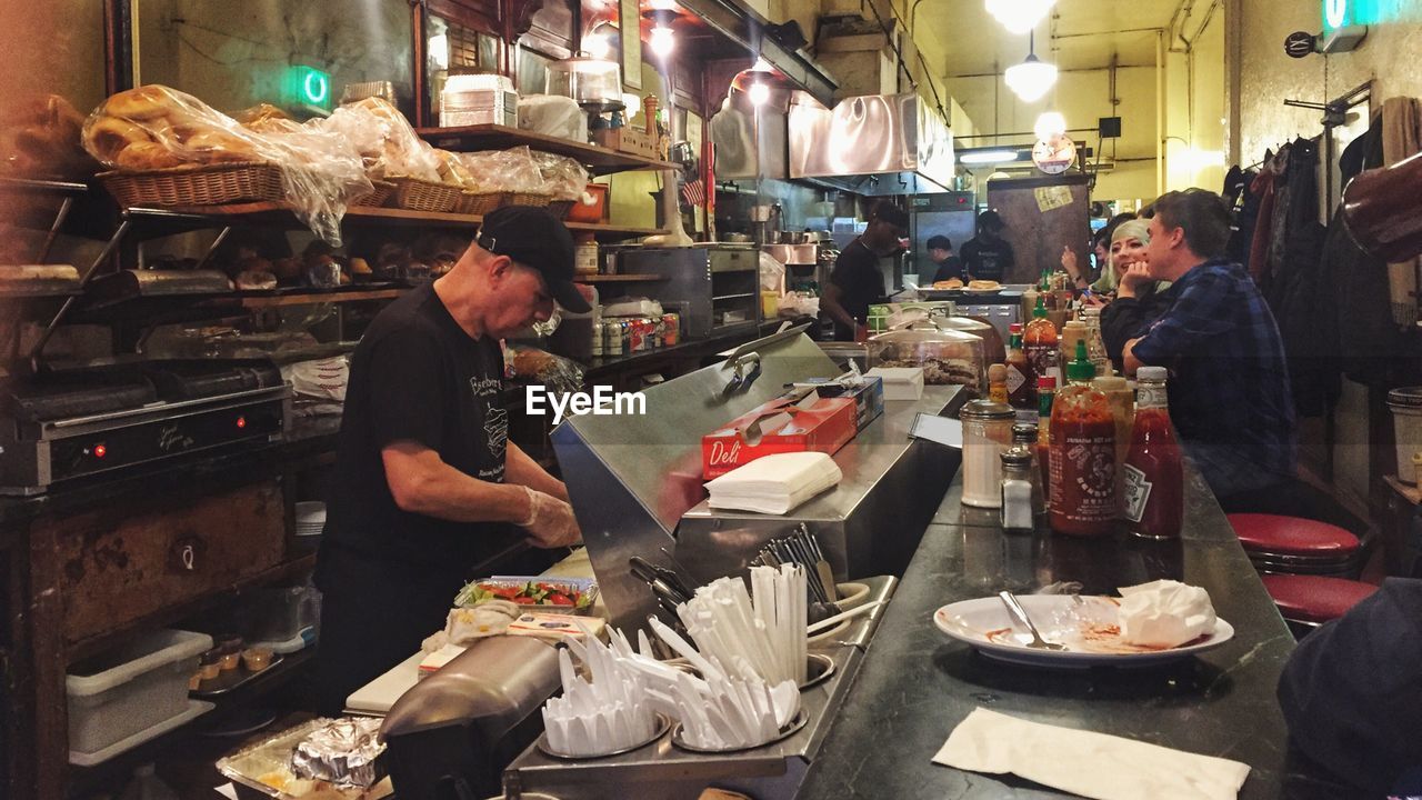 HIGH ANGLE VIEW OF PEOPLE WORKING AT RESTAURANT