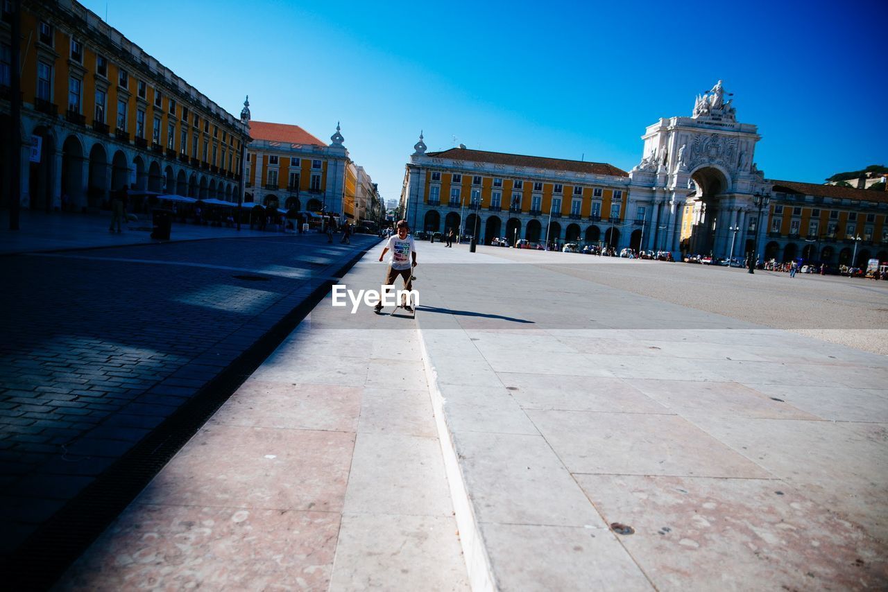 MAN WALKING IN TOWN SQUARE