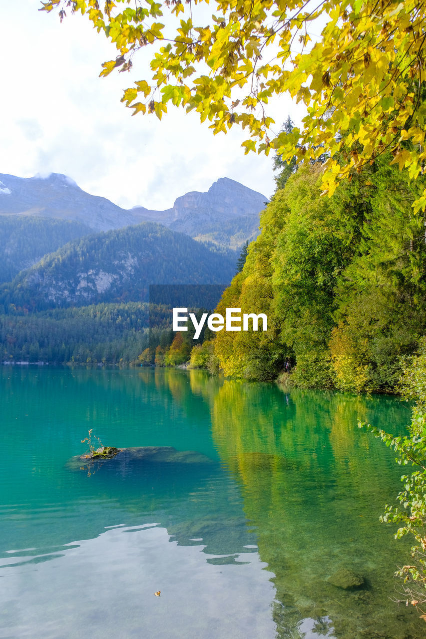 SCENIC VIEW OF LAKE BY TREE MOUNTAINS AGAINST SKY