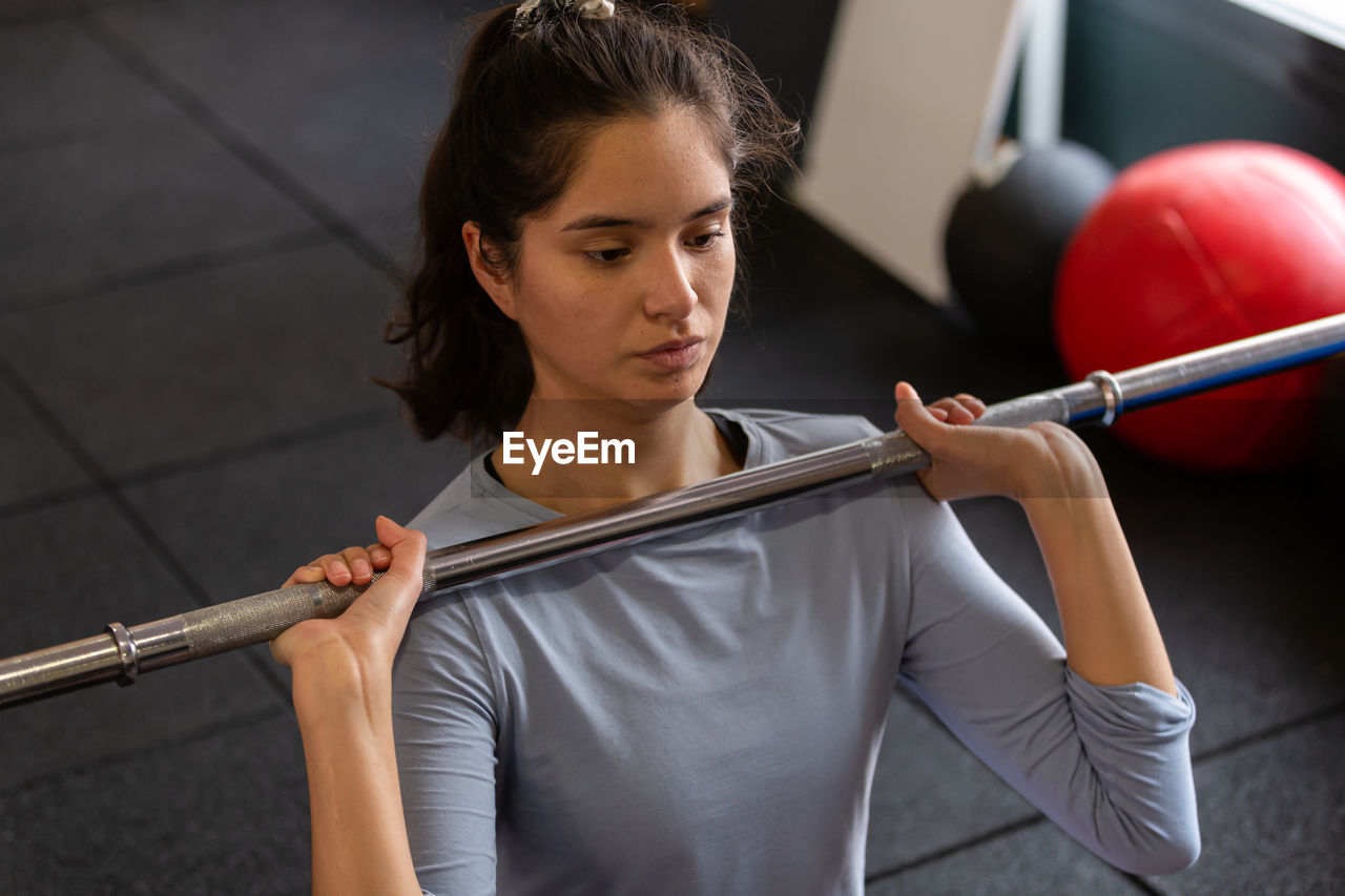 side view of young woman exercising in gym