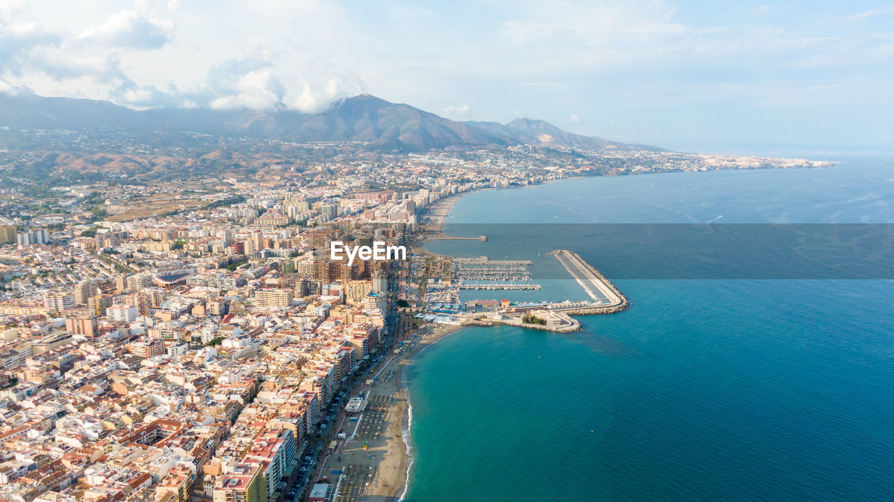 high angle view of cityscape by sea against sky