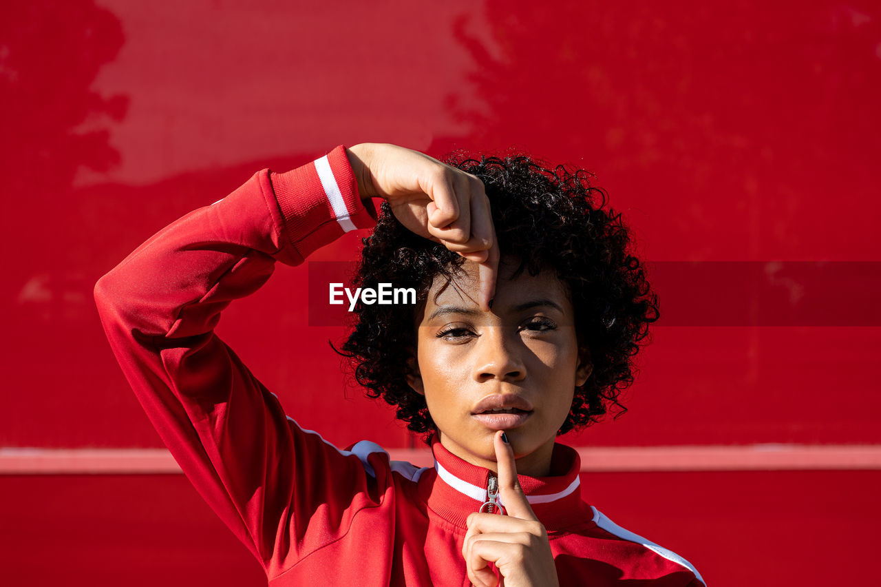 African american woman with short hair and urban dress with red background