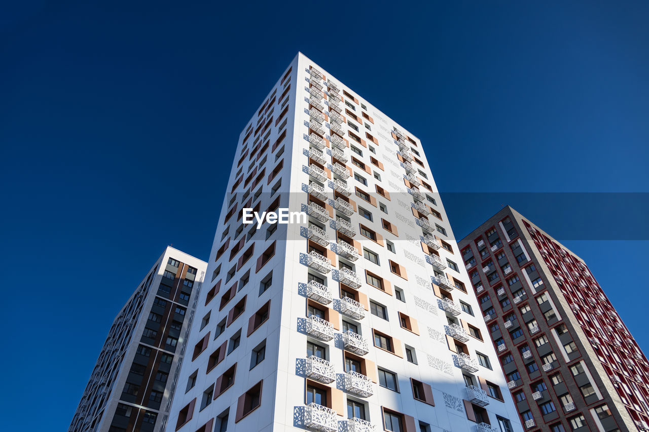 Low angle view of modern buildings against clear blue sky