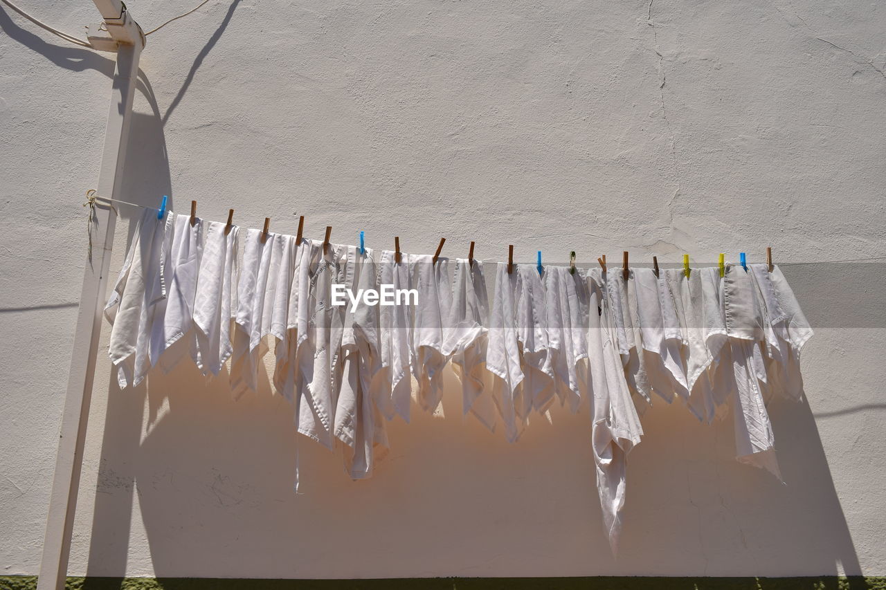Low angle view of clothesline hanging against wall