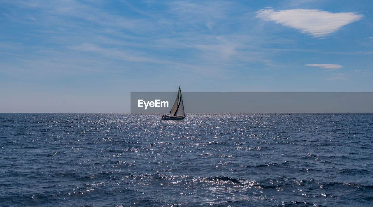 Sailboat sailing on sea against sky