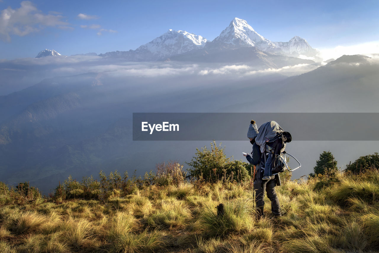 Woman standing on field against mountains