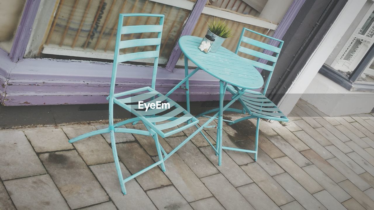 Blue chairs and table at sidewalk cafe