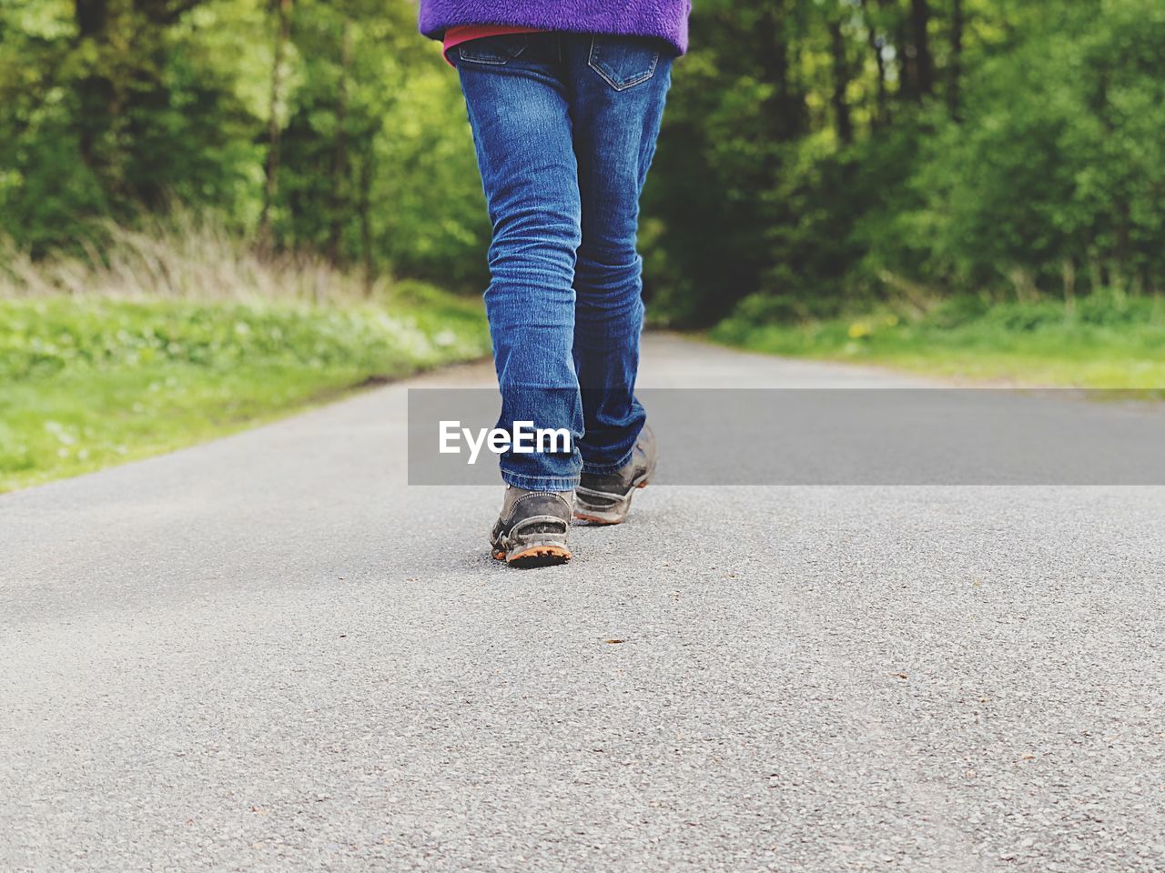 Low section of man walking on road