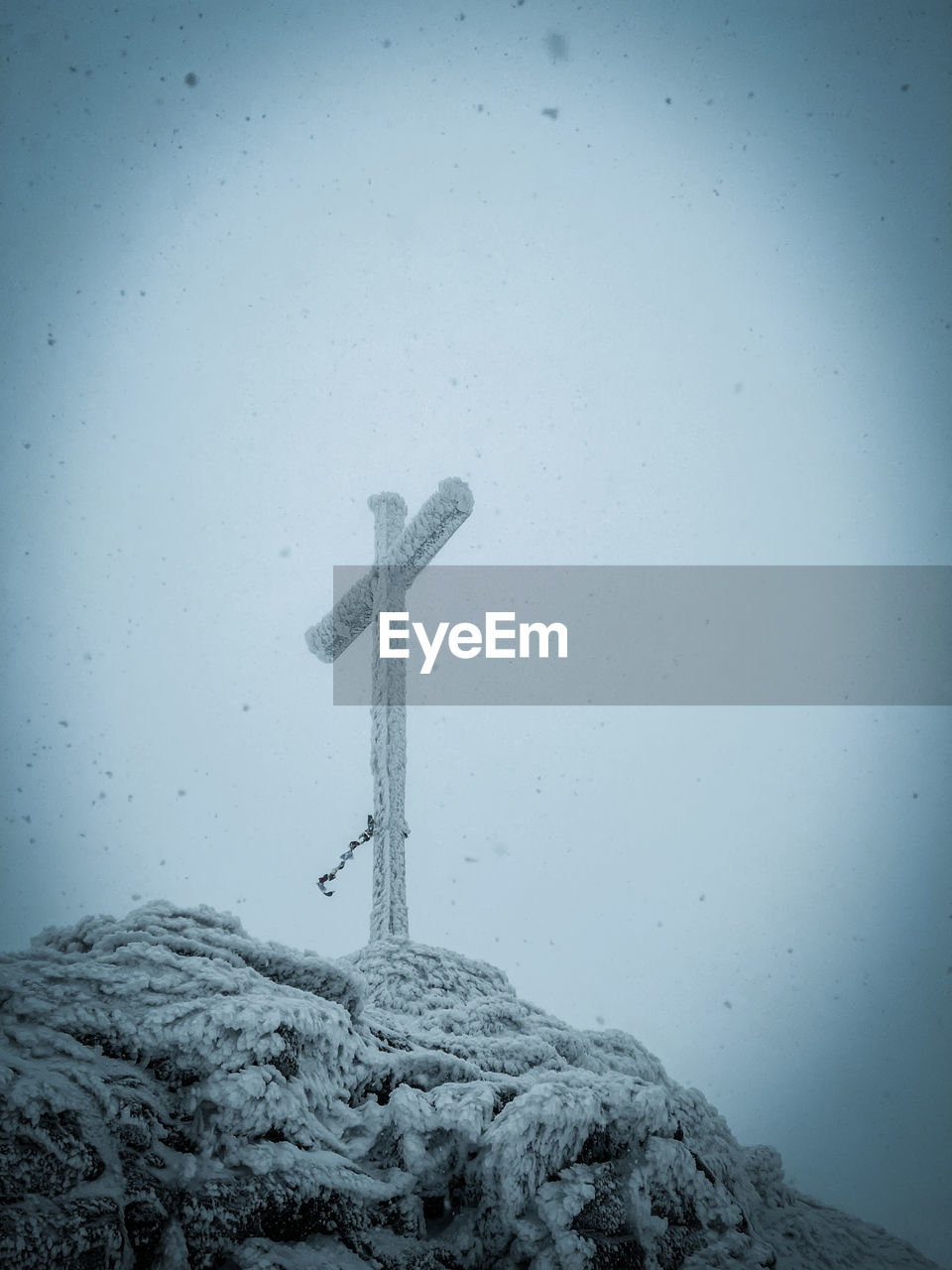 cross, snow, black and white, sky, monochrome, religion, no people, nature, spirituality, symbol, belief, cold temperature, monochrome photography, grave, cemetery, winter, crucifix, blue, environment, darkness, outdoors, catholicism, wind, cross shape