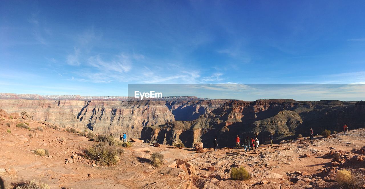 People at grand canyon against sky