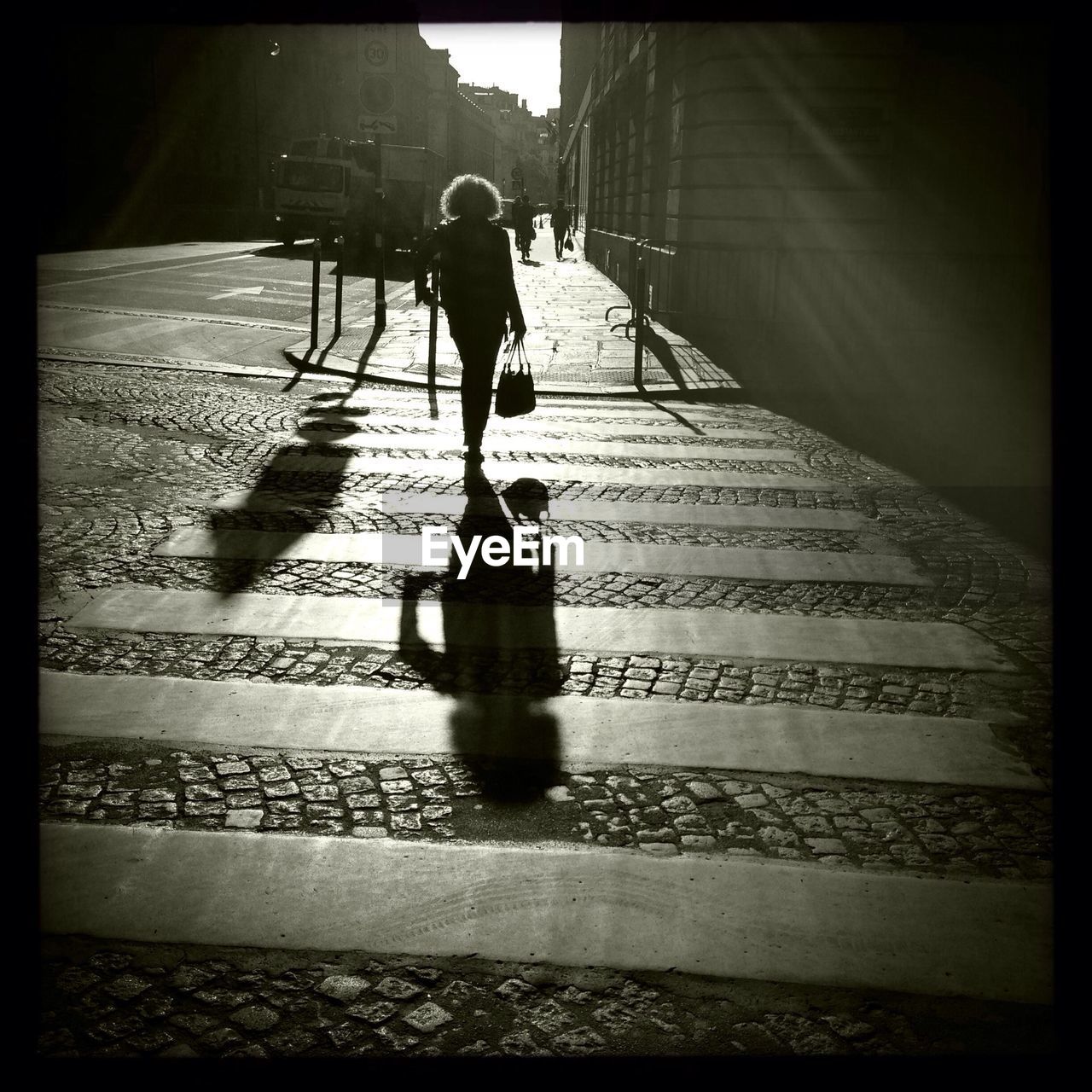 Silhouette of woman on zebra crossing