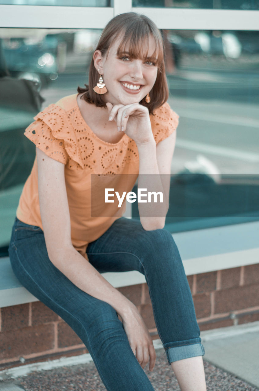 Portrait of smiling young woman sitting outdoors