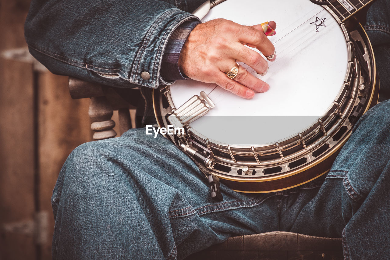 Midsection of man playing banjo