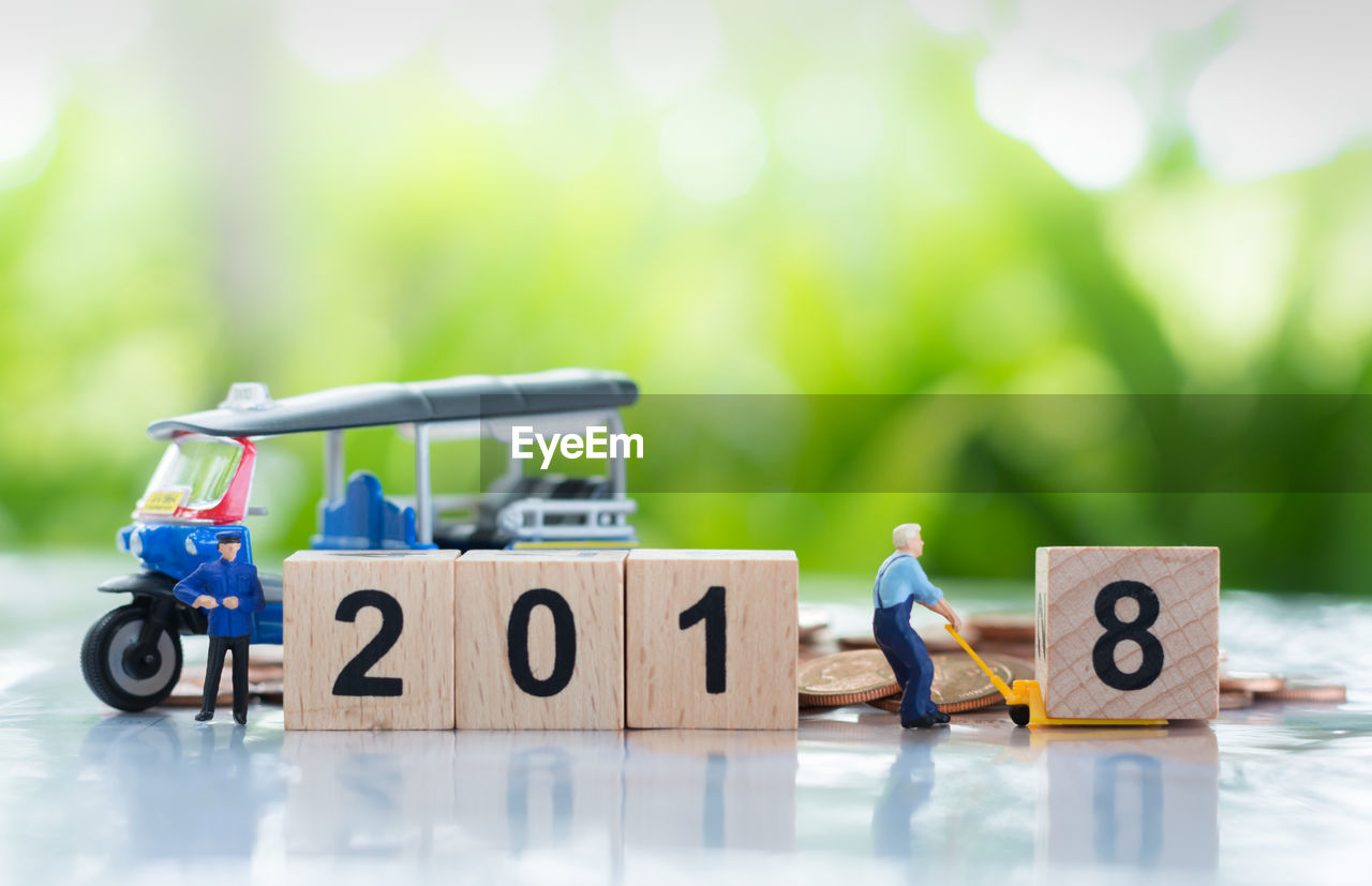 Close-up of wooden blocks with figurines on table at yard