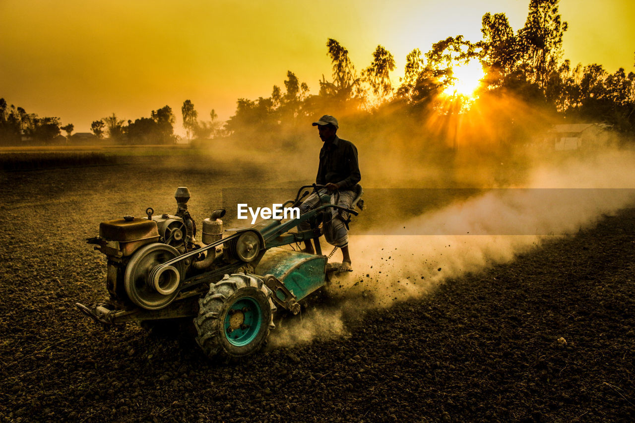 Man on agricultural vehicle in farm