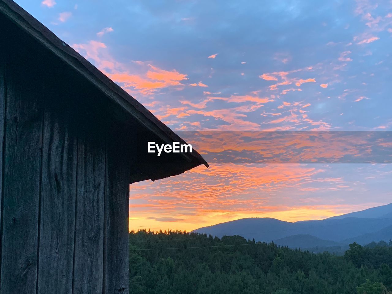 SCENIC VIEW OF SILHOUETTE MOUNTAINS AGAINST ORANGE SKY