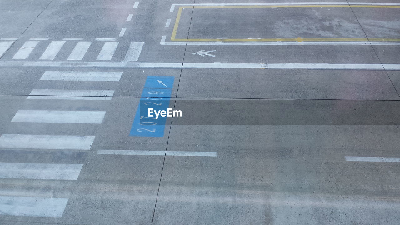 High angle view of arrow sign on road of the airport 