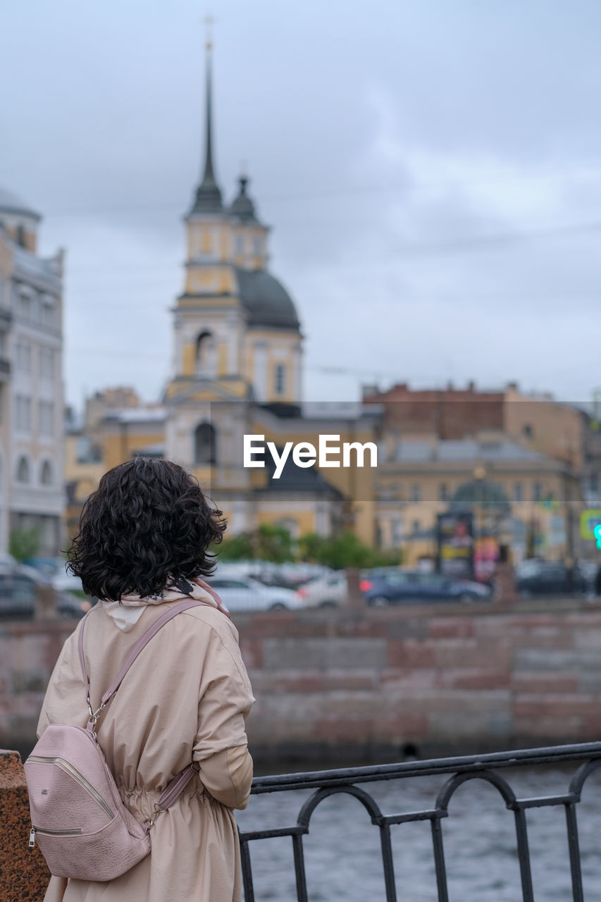 Rear view of woman looking at buildings in city