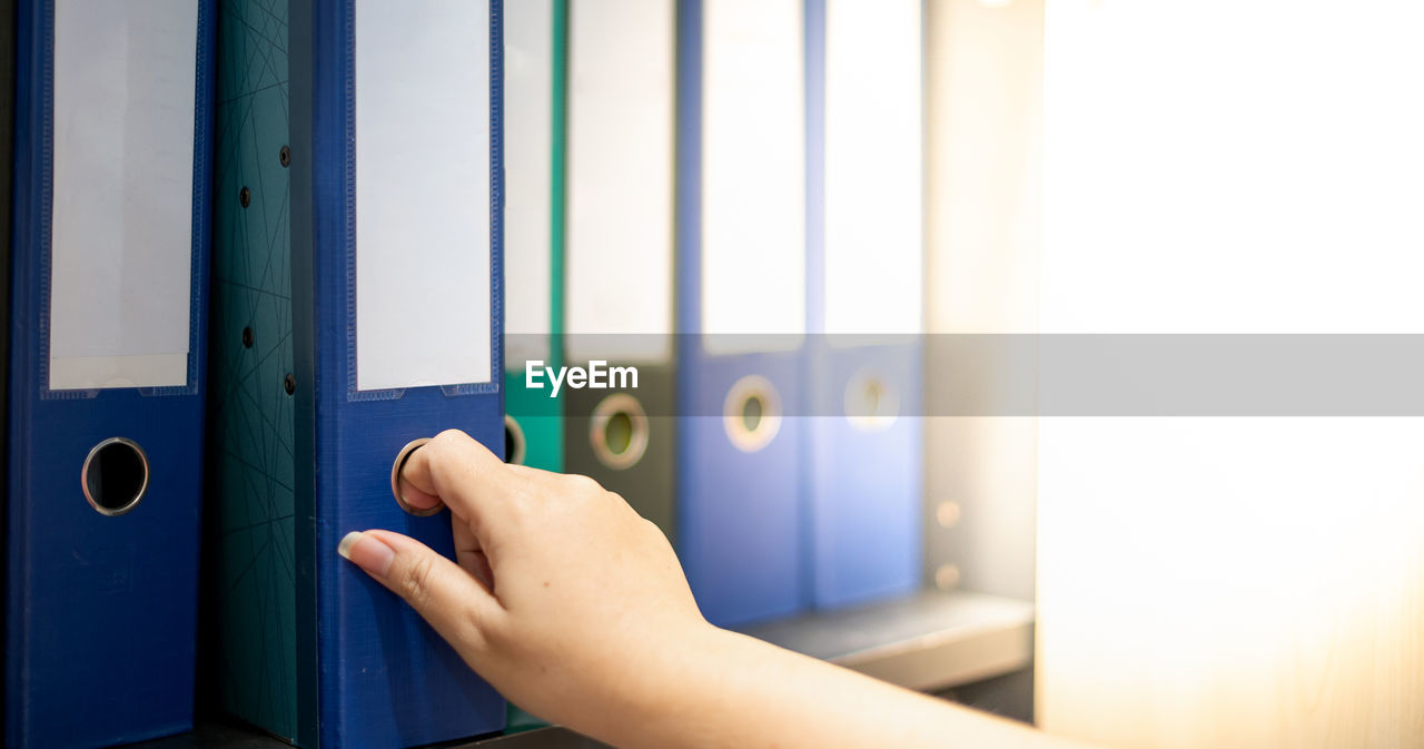 CLOSE-UP OF HUMAN HAND HOLDING BLUE DOOR