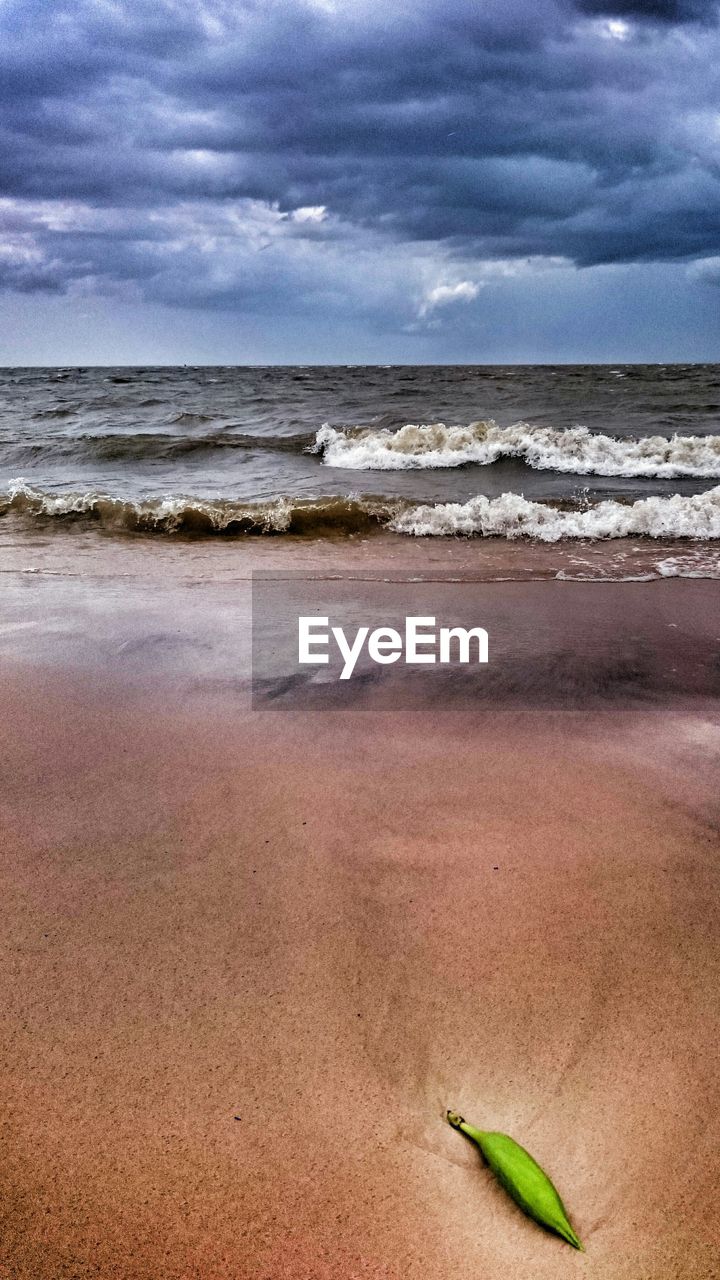 VIEW OF BEACH AGAINST CLOUDY SKY