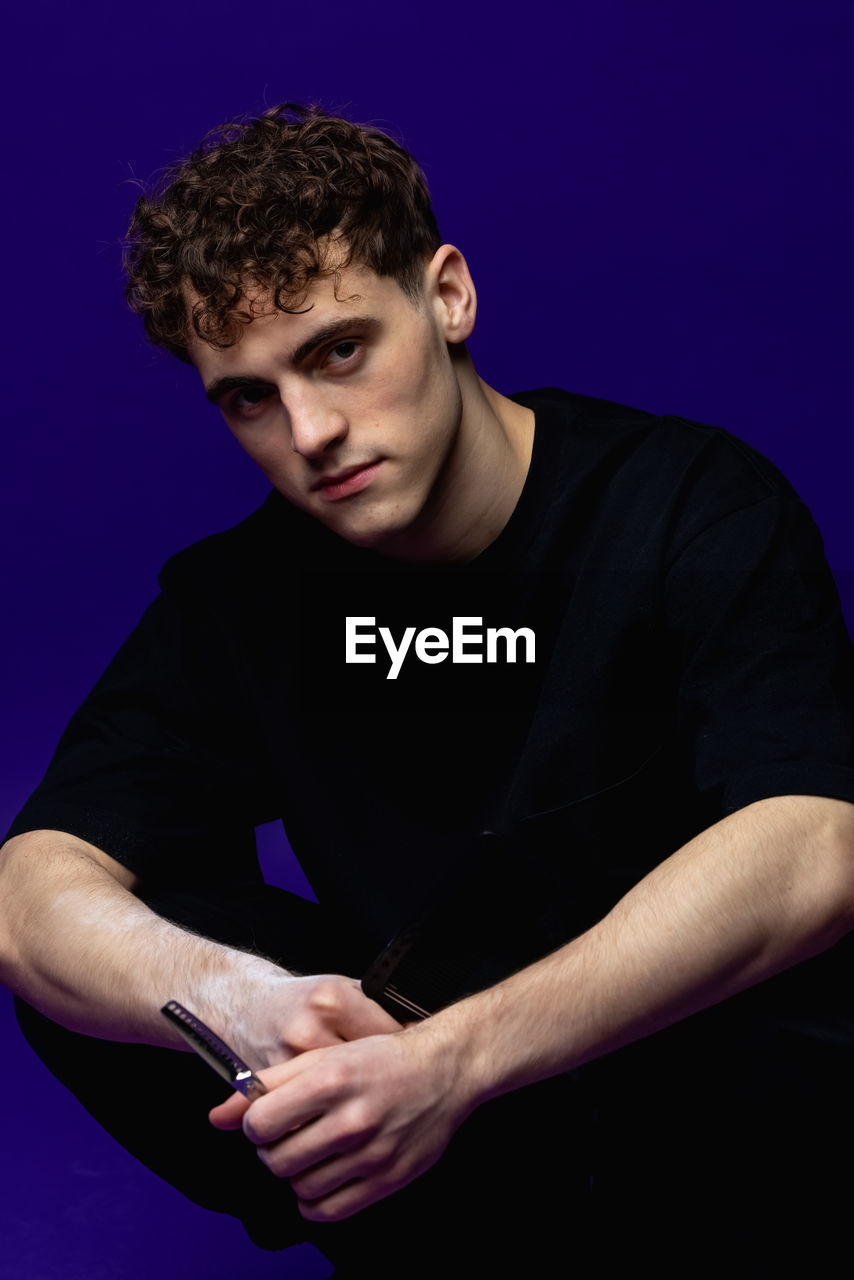 Portrait of young man against black background