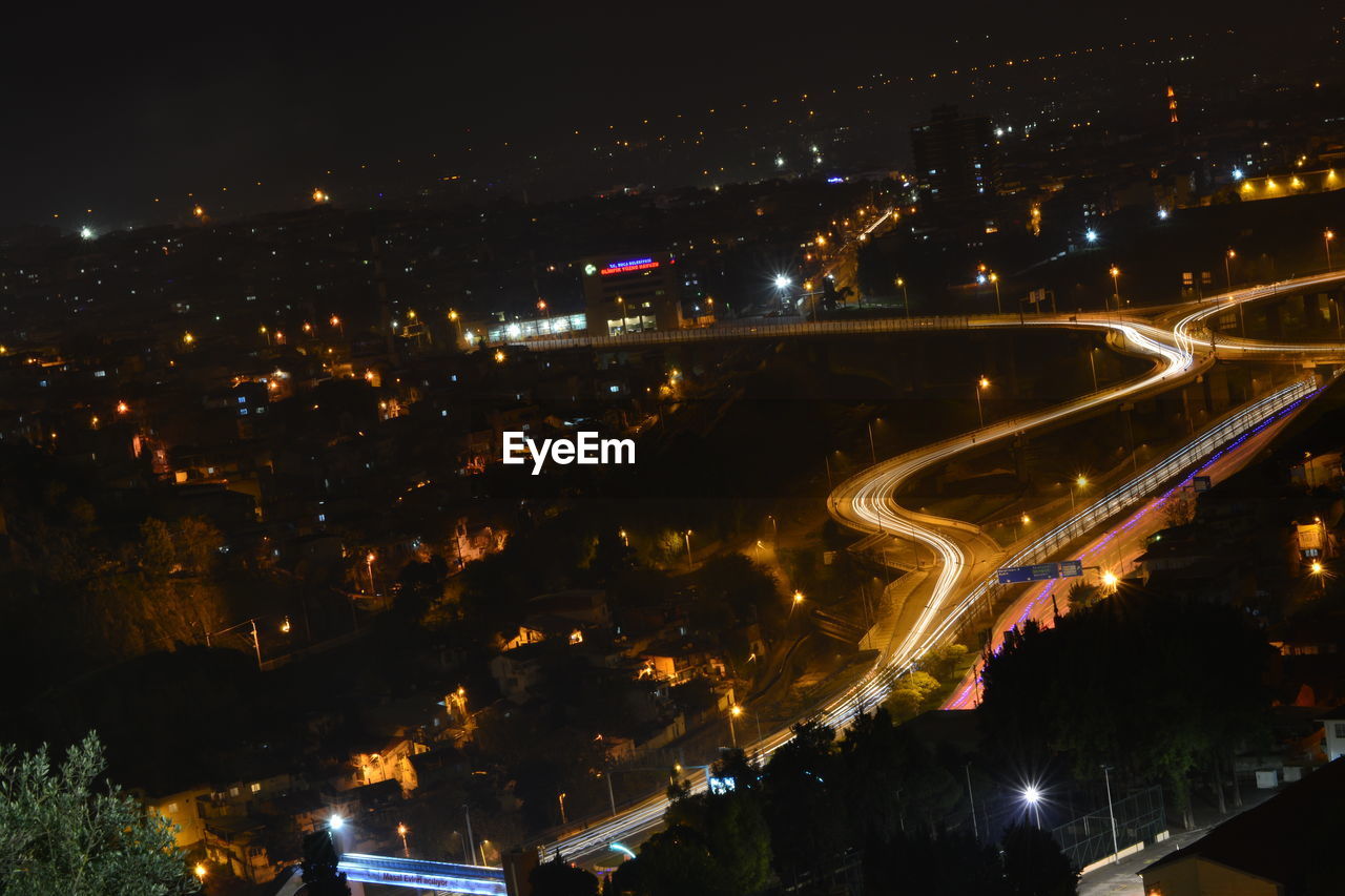 HIGH ANGLE VIEW OF ILLUMINATED BUILDINGS AT NIGHT