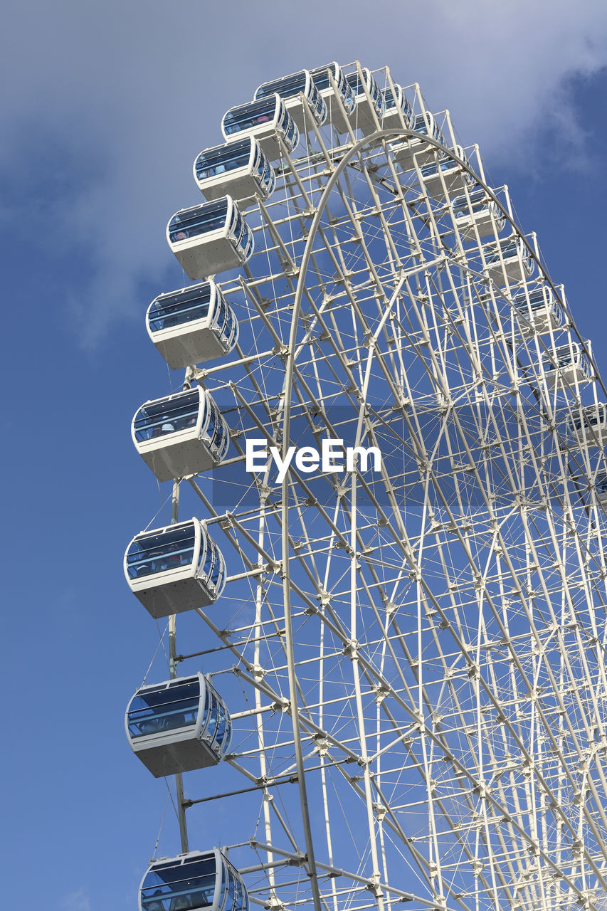 Low angle view of ferris wheel against blue sky