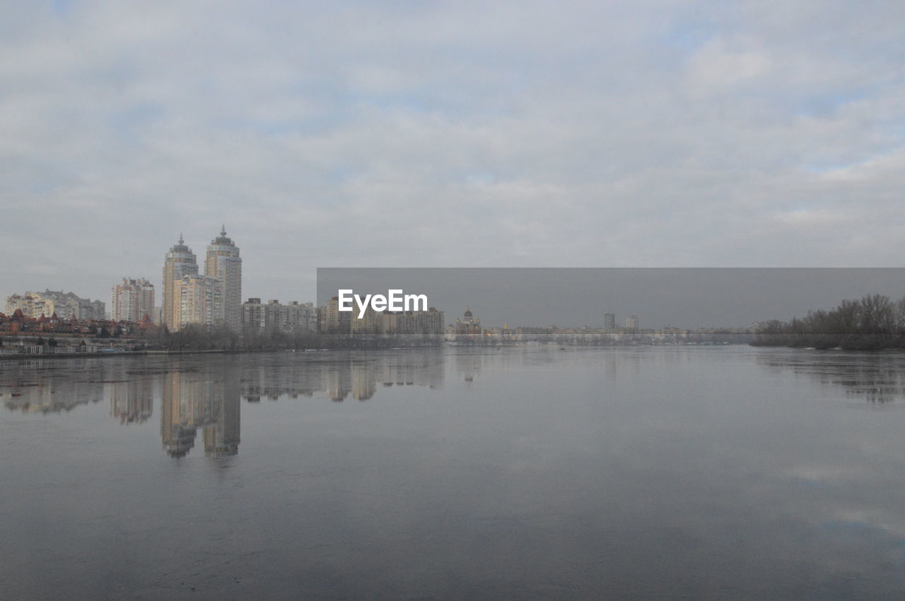 LAKE AND BUILDINGS AGAINST SKY