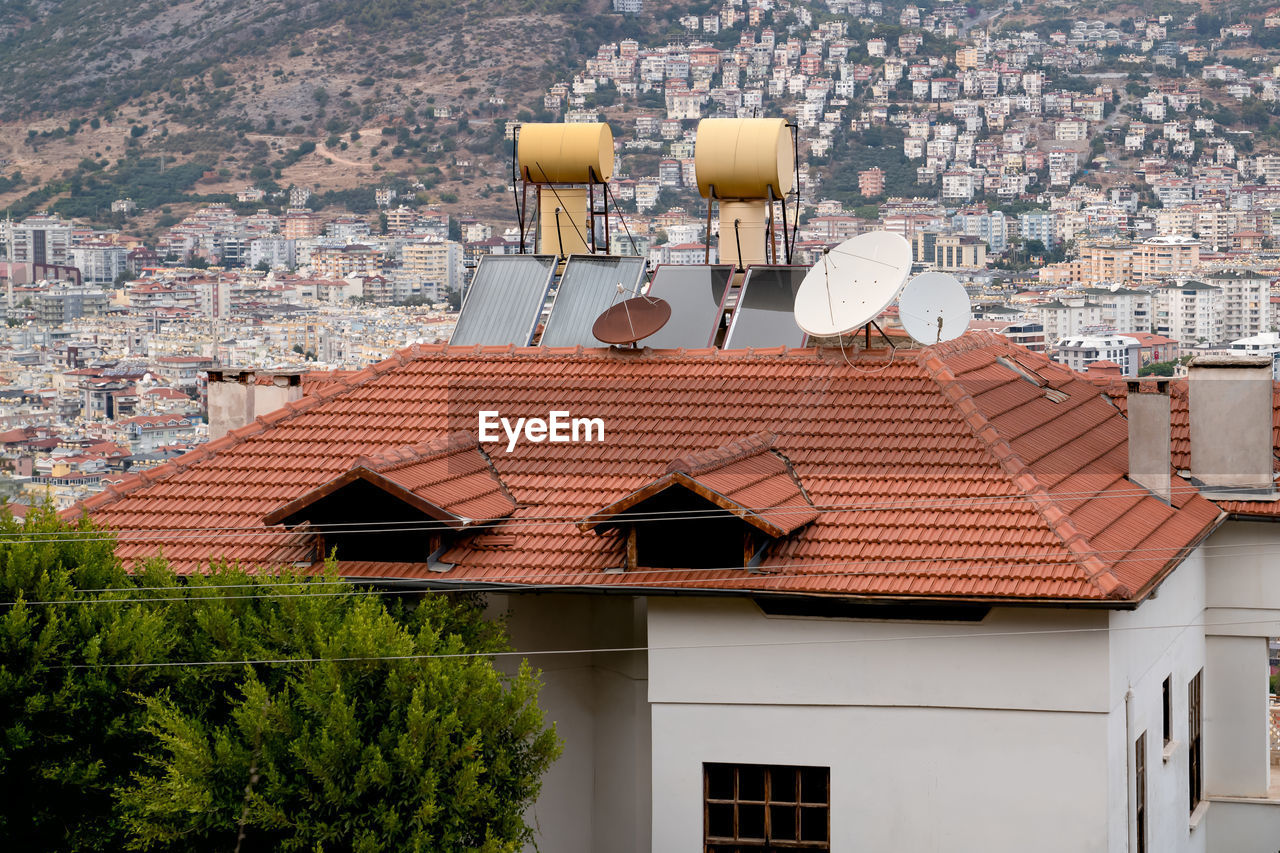 Barrels of water heated by solar batteries installed on roof of house. concept saving electricity.