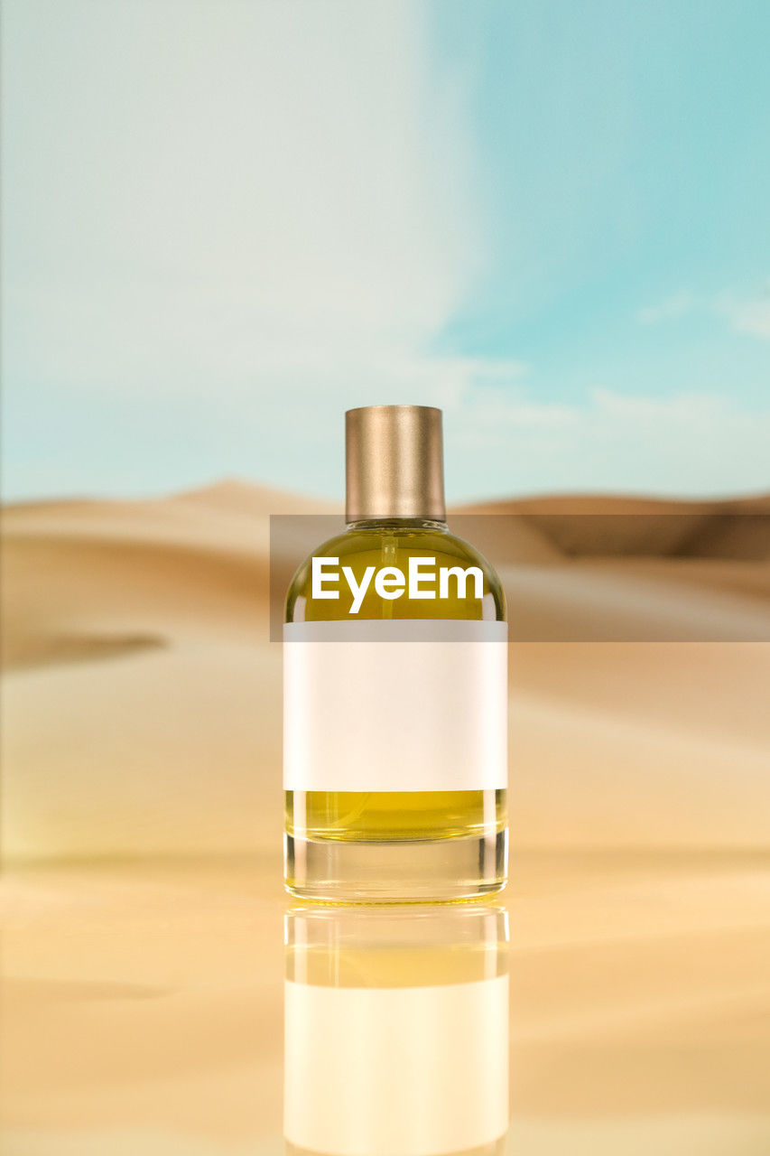 A plain perfume yellow liquid on a desert background