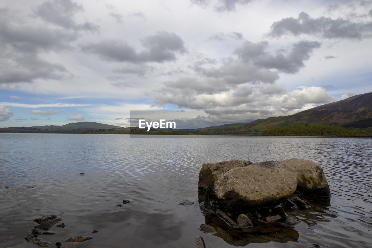 water, lake, reflection, cloud, sky, nature, mountain, scenics - nature, environment, shore, beauty in nature, body of water, landscape, reservoir, tranquility, no people, land, tranquil scene, mountain range, coast, travel destinations, outdoors, morning, day, rock, beach, travel, non-urban scene, bay, wilderness, overcast, highland