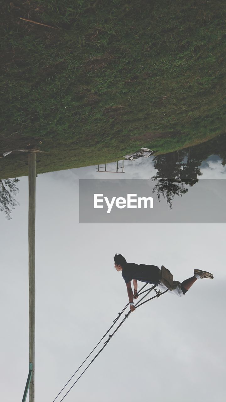 Man standing by tree against sky