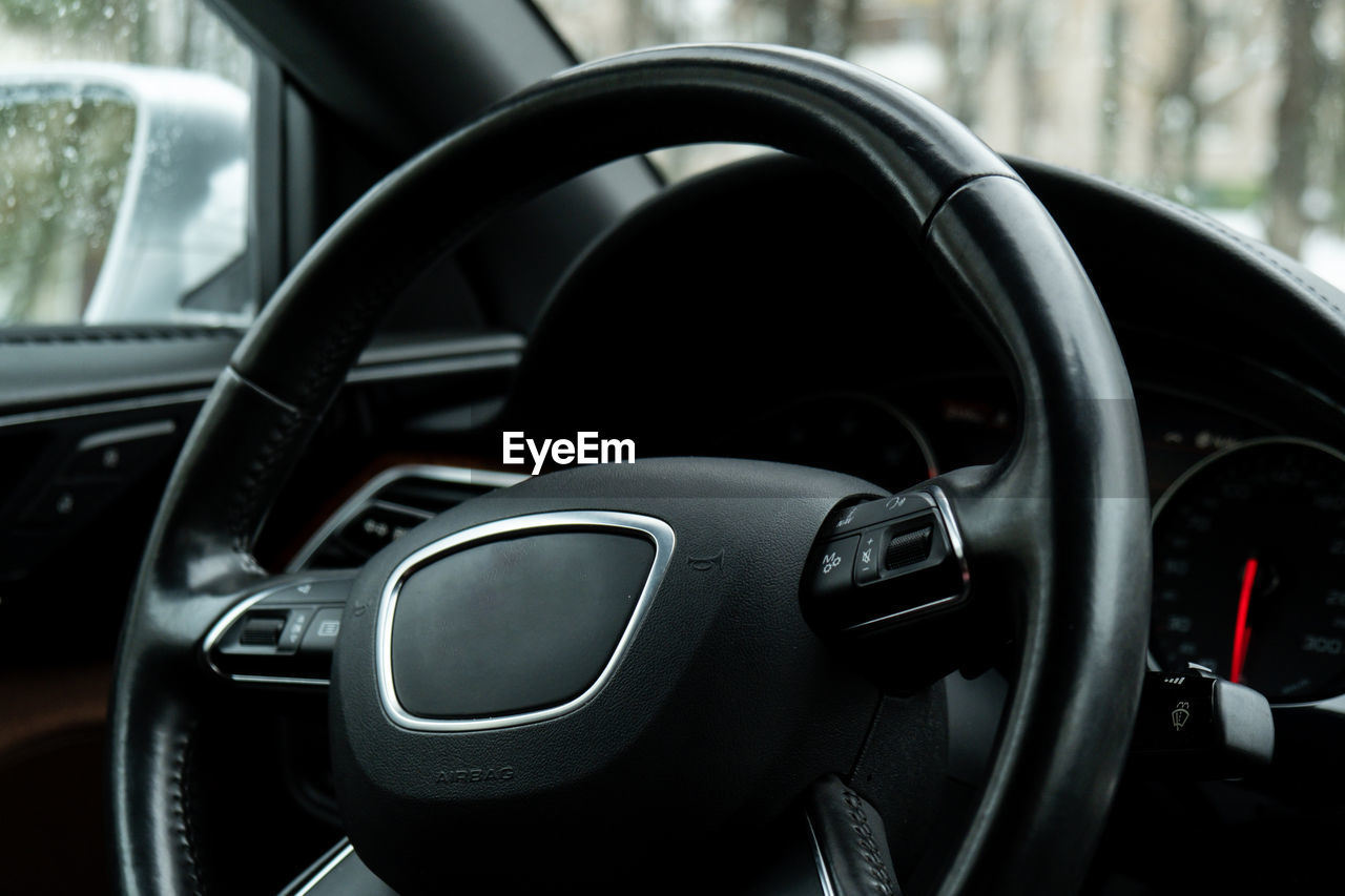 Black luxury modern car interior. steering wheel, shift lever and dashboard. detail automatic gear