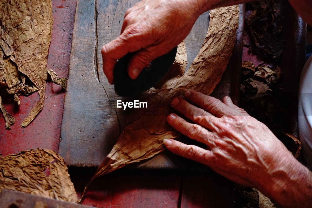 CLOSE-UP OF MAN WORKING ON WOODEN FLOOR