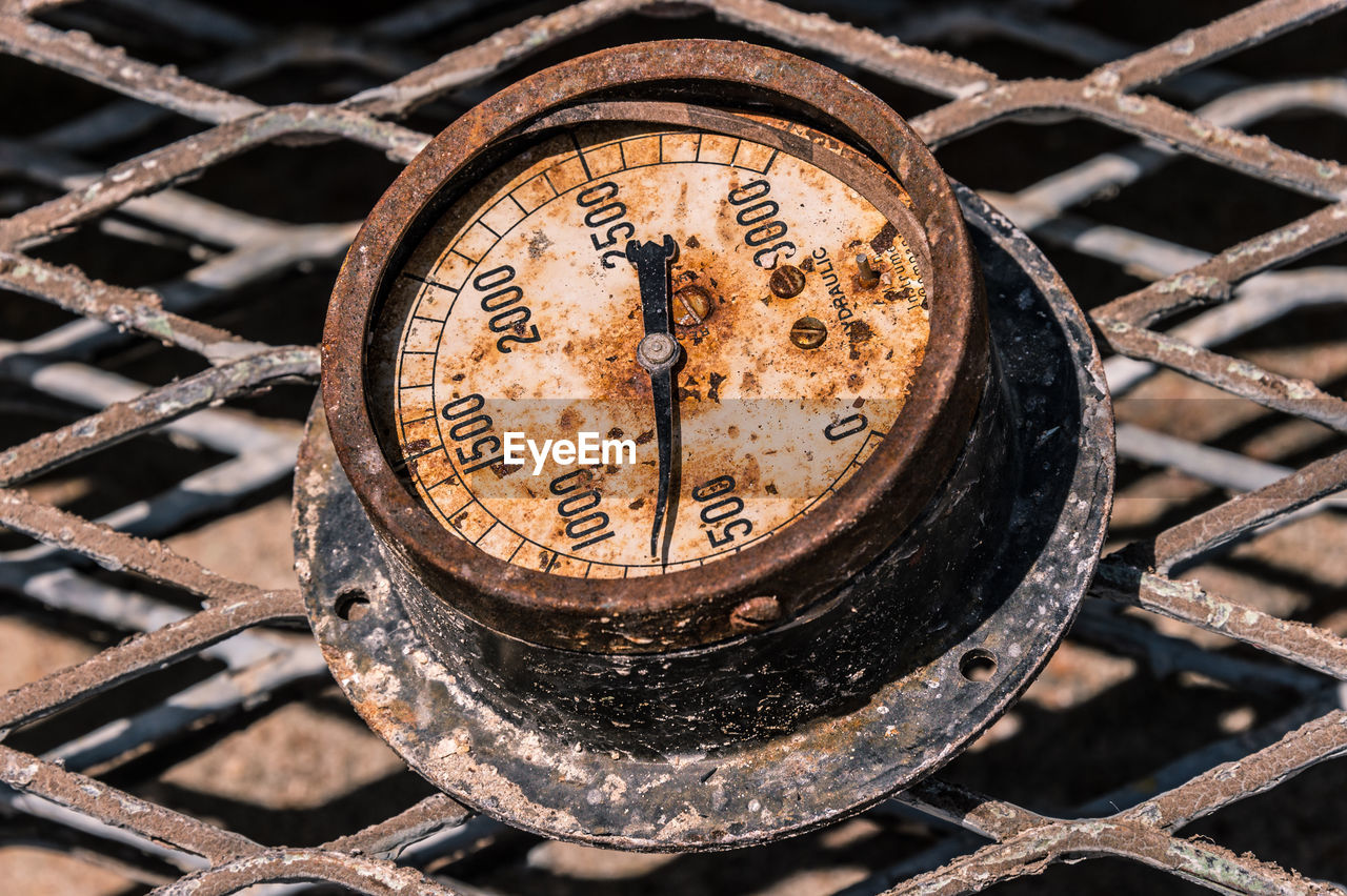 Close-up of rusty gauge on fence