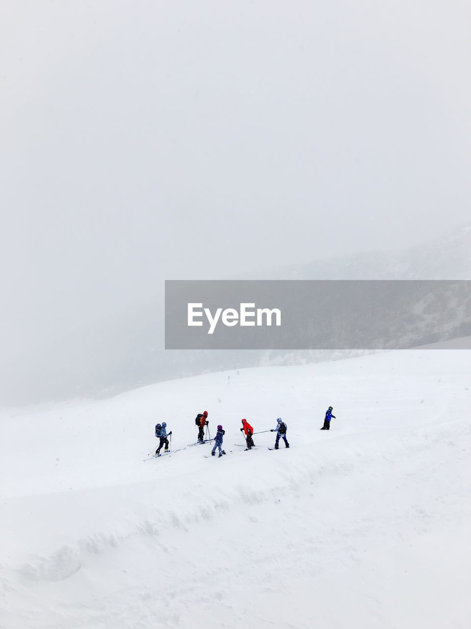 People on snowcapped mountain against sky