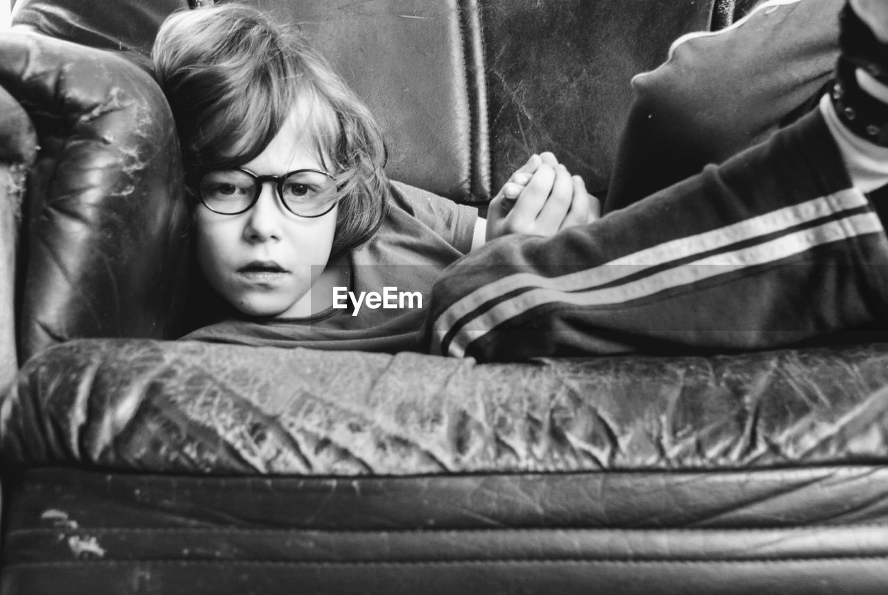 Portrait of boy lying on sofa at home