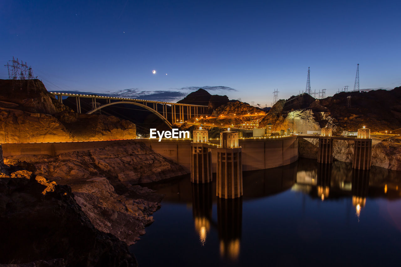 Illuminated hoover dam against sky at dusk