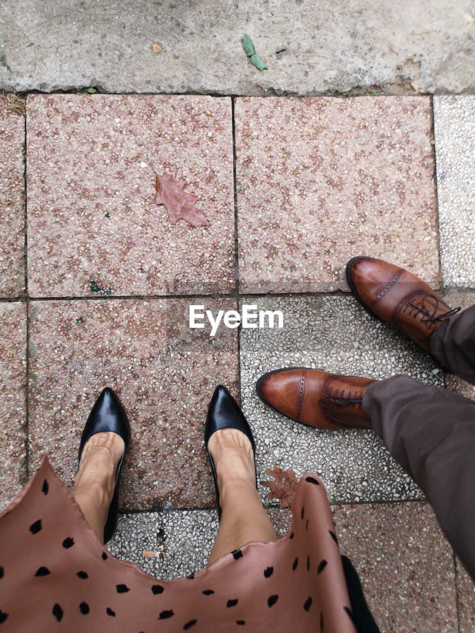 Low section of couple standing on footpath