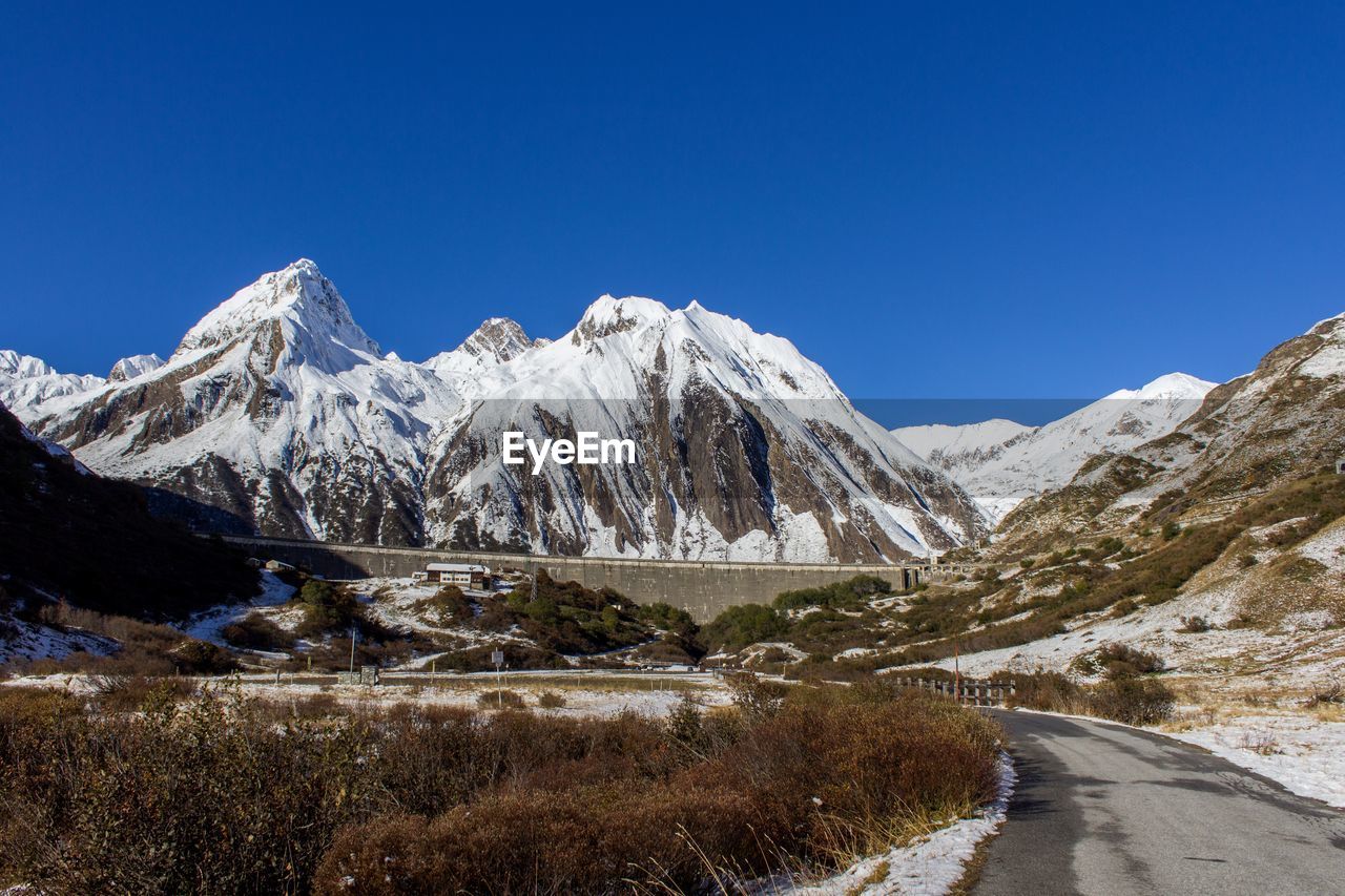 Landscape against snow covered rocky mountain range