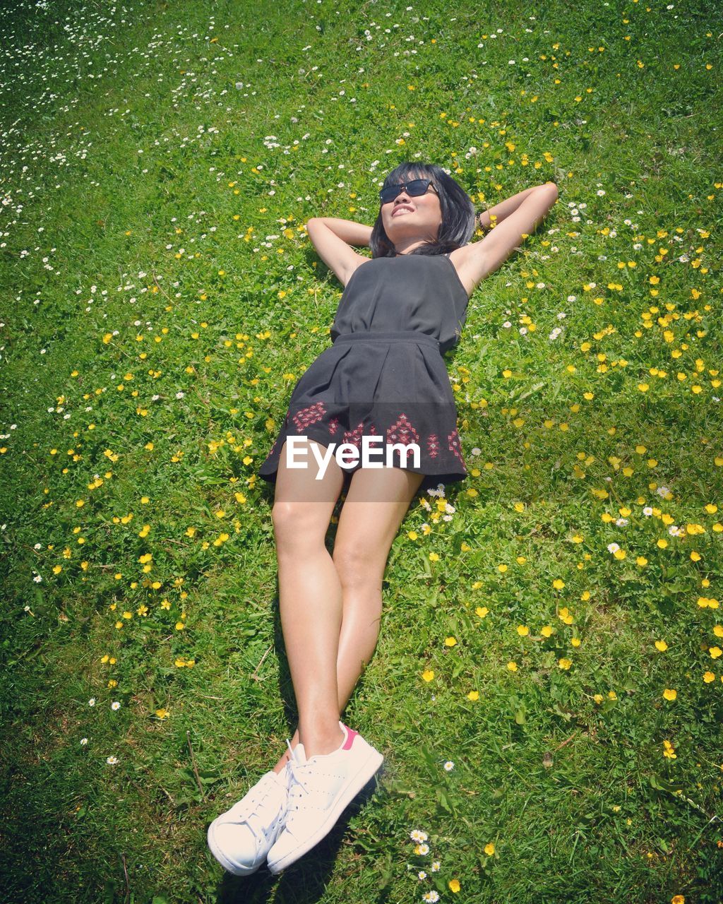 High angle view of woman lying on grassy field