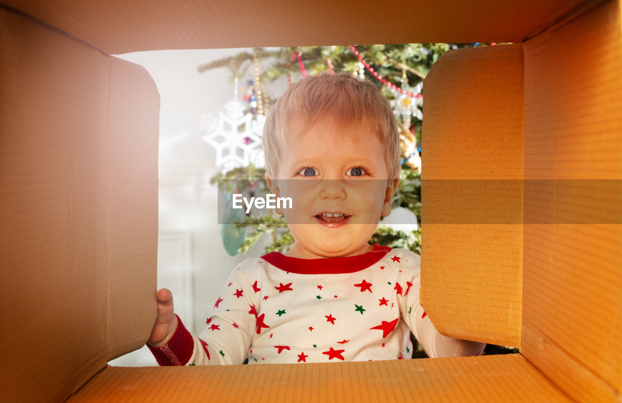 portrait of cute boy using laptop while sitting on sofa at home