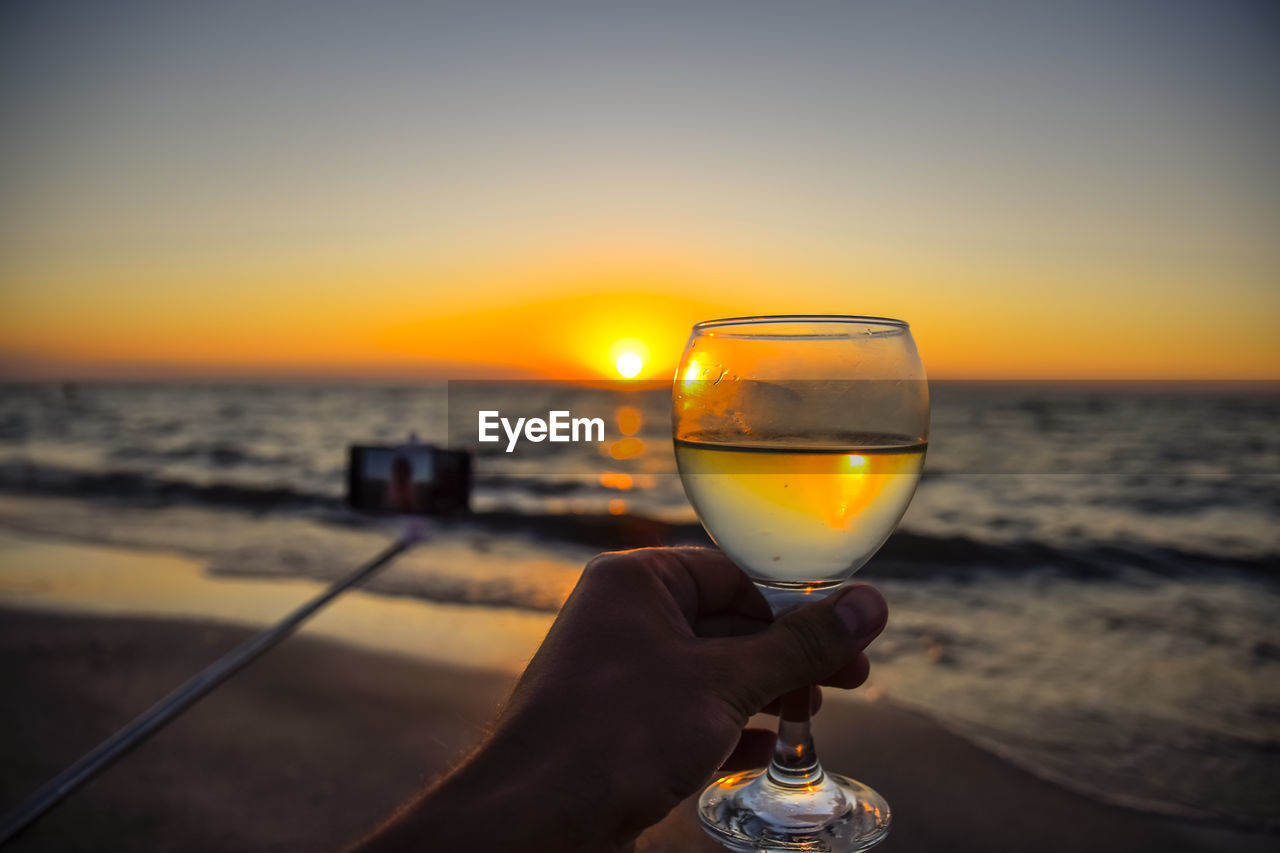 CLOSE-UP OF HAND HOLDING WINE GLASS