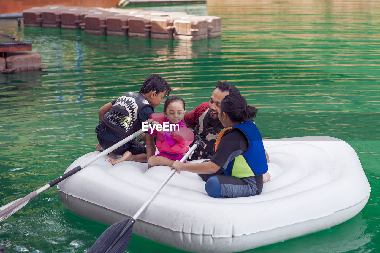 PEOPLE SITTING ON BOAT IN WATER