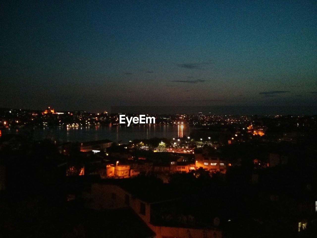 VIEW OF ILLUMINATED CITYSCAPE AT NIGHT